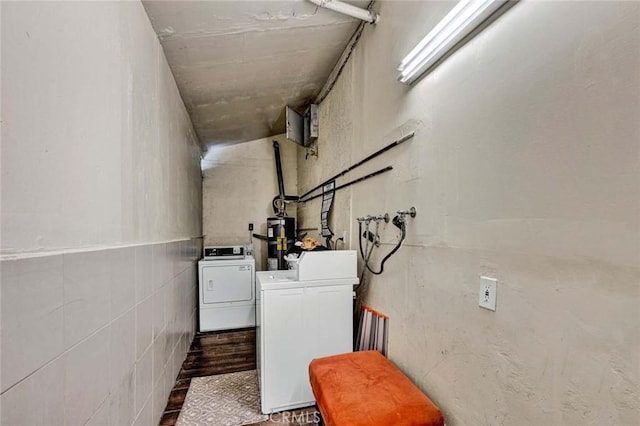 interior space featuring strapped water heater, wood finished floors, and washing machine and clothes dryer