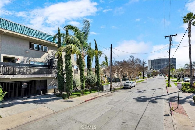 view of street featuring curbs, street lights, and sidewalks