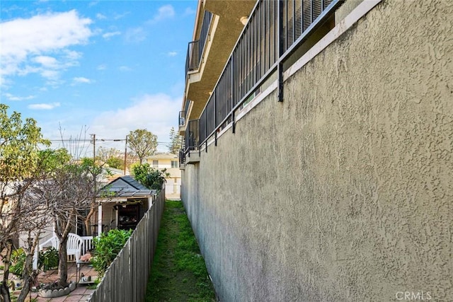 view of home's exterior with stucco siding and fence