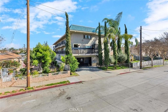 exterior space with a fenced front yard, stucco siding, and concrete driveway