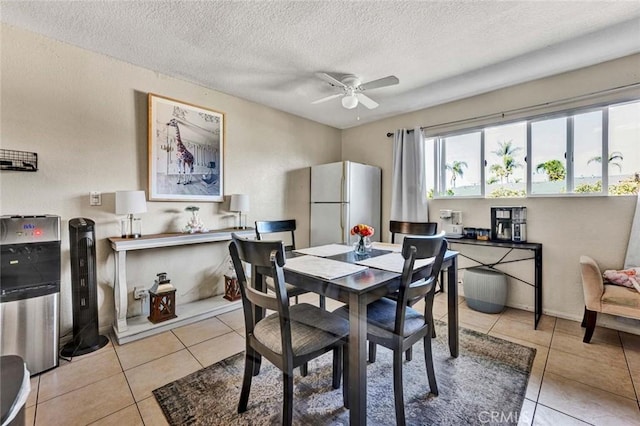 dining room with a textured ceiling, tile patterned floors, and ceiling fan