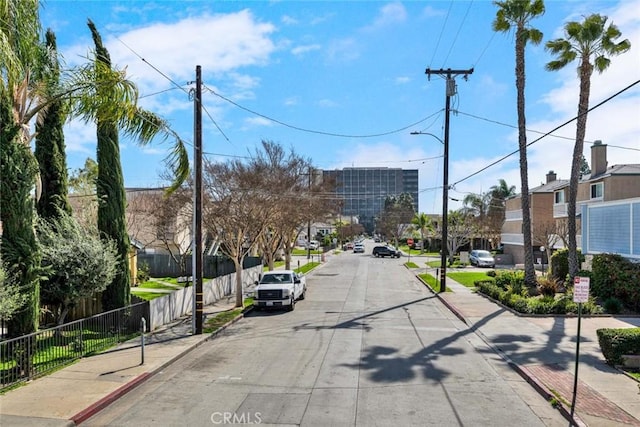 view of street with curbs, traffic signs, and sidewalks