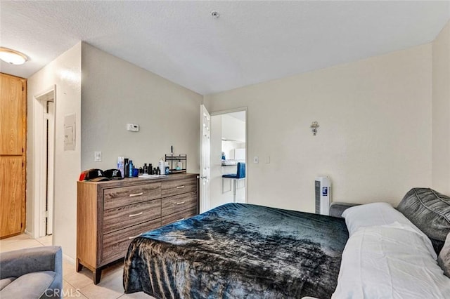 bedroom with light tile patterned floors and a textured ceiling