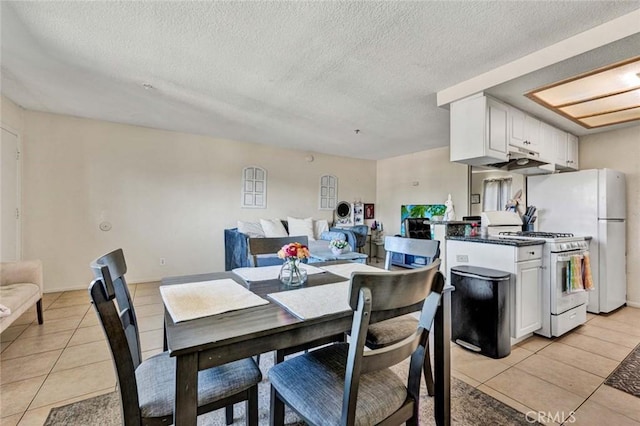 dining area with light tile patterned floors and a textured ceiling