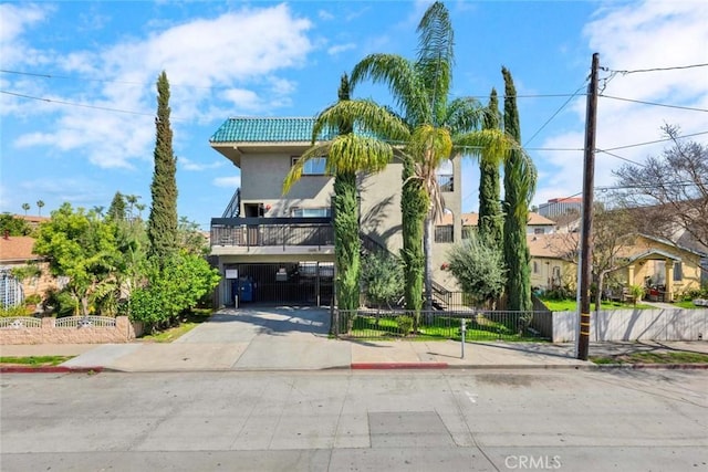 view of front of home with stucco siding, a tile roof, and fence