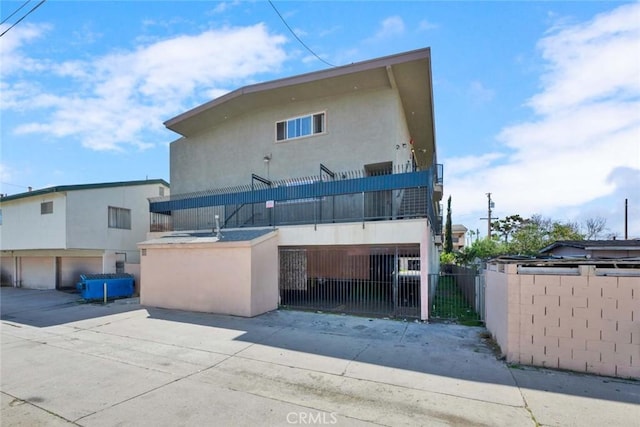 rear view of property featuring stucco siding and a fenced front yard