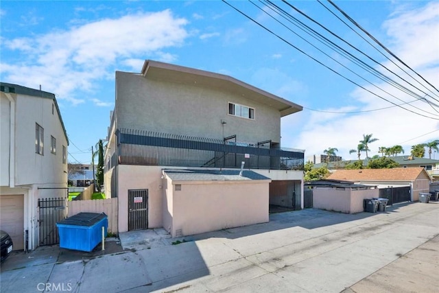 view of front of home featuring a gate, stucco siding, and fence