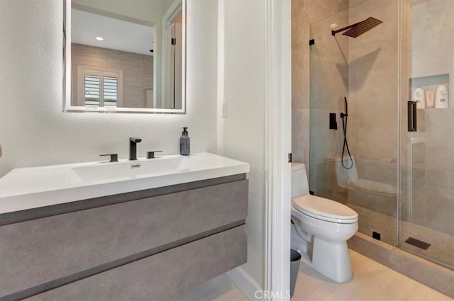 full bathroom featuring vanity, a shower stall, toilet, and tile patterned flooring