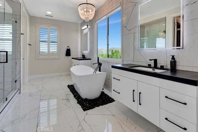 full bath featuring a marble finish shower, marble finish floor, a freestanding tub, and a sink