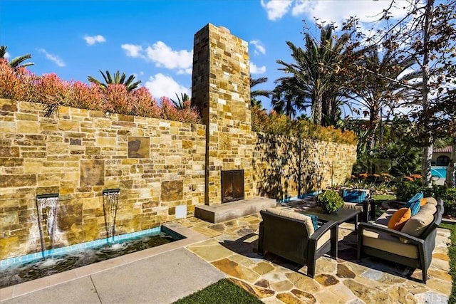 view of patio featuring an outdoor stone fireplace