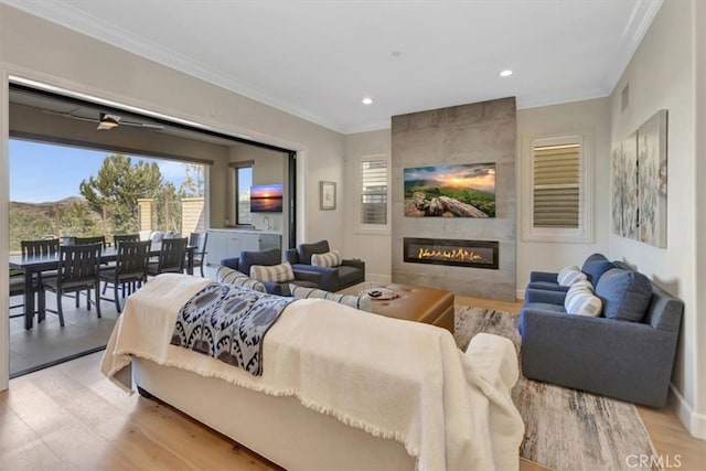 bedroom featuring visible vents, light wood-style flooring, a fireplace, crown molding, and access to outside