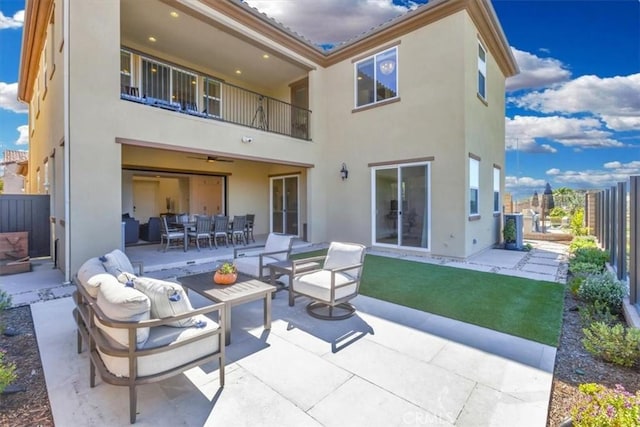 back of property featuring outdoor dining space, a balcony, a patio area, and stucco siding