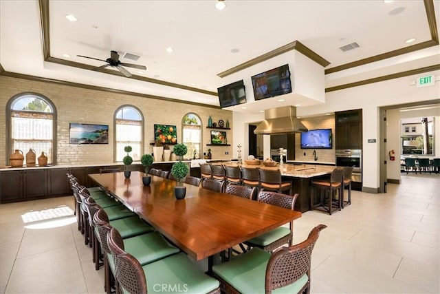 dining space with a tray ceiling, visible vents, ornamental molding, and light tile patterned flooring