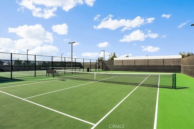 view of tennis court featuring fence