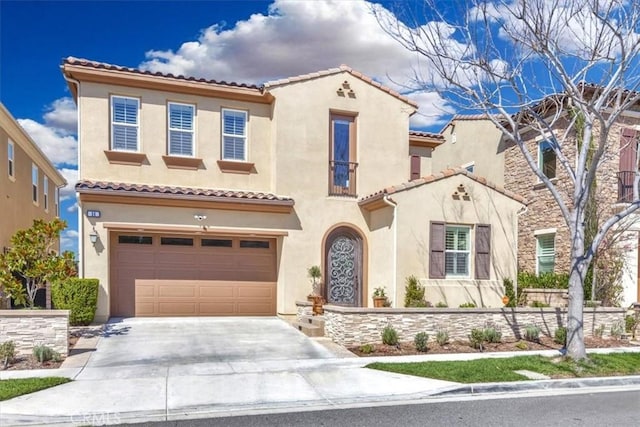 mediterranean / spanish home with a tiled roof, stucco siding, driveway, and a garage