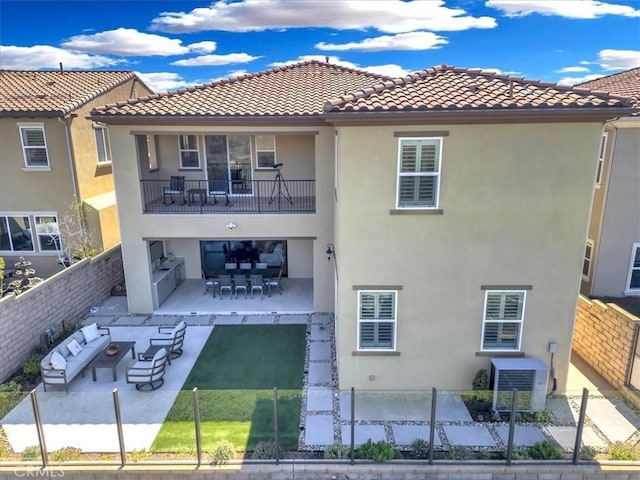 rear view of property featuring a balcony, central AC, a fenced backyard, and a patio area