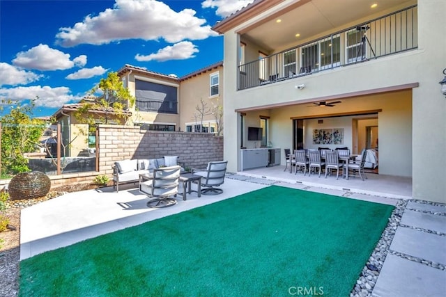 back of property featuring an outdoor living space, a balcony, a patio area, and stucco siding