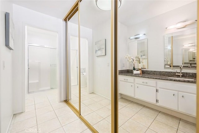 bathroom with tile patterned floors, vanity, and baseboards