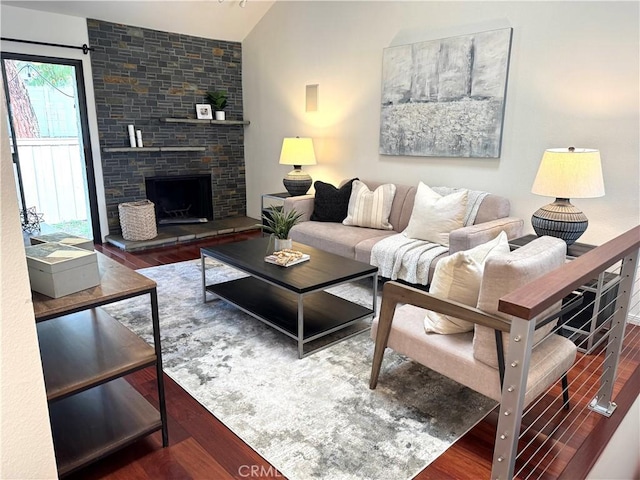 living area featuring a fireplace, lofted ceiling, and wood finished floors