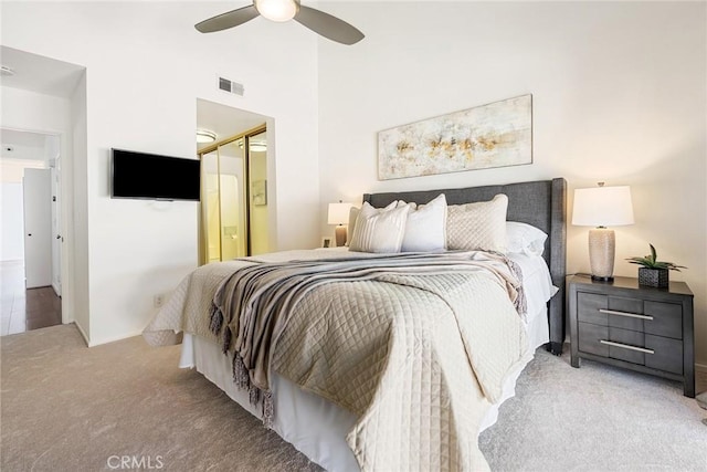 bedroom with a ceiling fan, visible vents, and light carpet