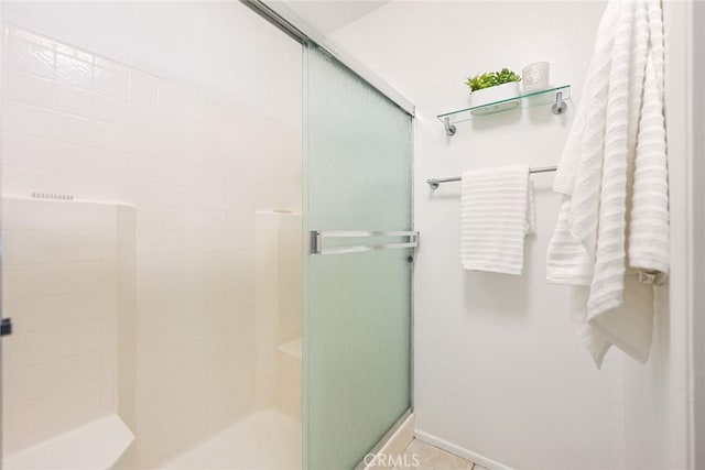 bathroom with baseboards and a stall shower