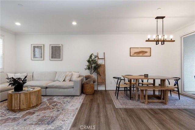 living room featuring crown molding, recessed lighting, wood finished floors, and a chandelier