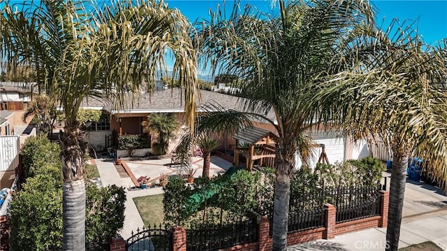 obstructed view of property featuring a fenced front yard and a garage