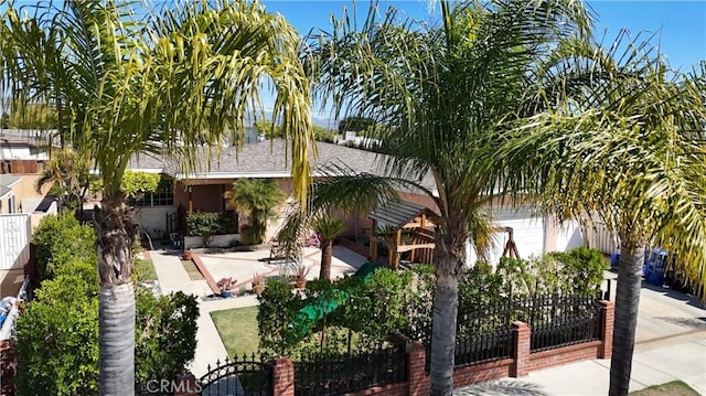 view of front of house with a garage, a patio, and fence