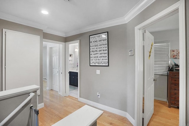 hallway with an upstairs landing, light wood-type flooring, baseboards, and ornamental molding