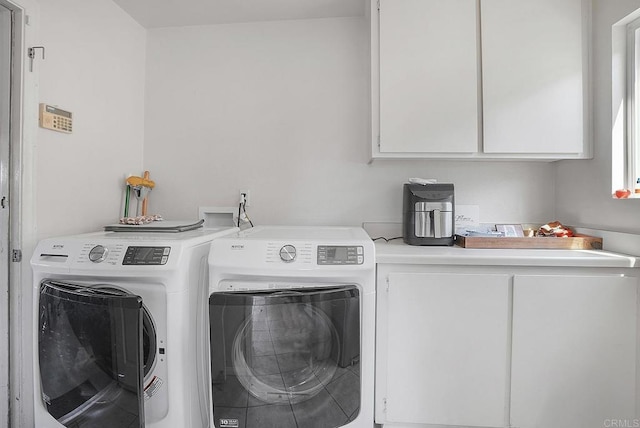 clothes washing area featuring cabinet space and independent washer and dryer