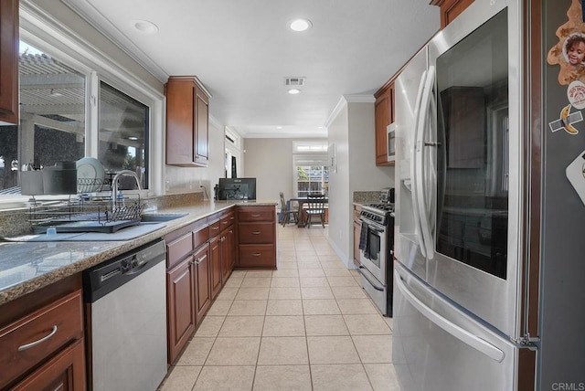 kitchen featuring visible vents, crown molding, light tile patterned floors, light stone counters, and appliances with stainless steel finishes