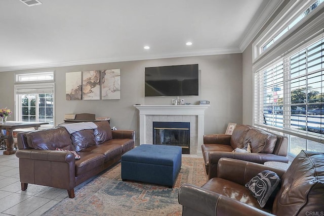 tiled living area with recessed lighting, visible vents, crown molding, and a tiled fireplace