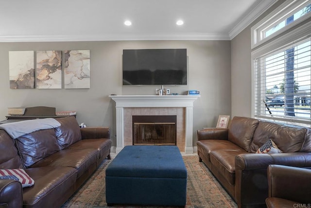 living room with recessed lighting, crown molding, and a tile fireplace