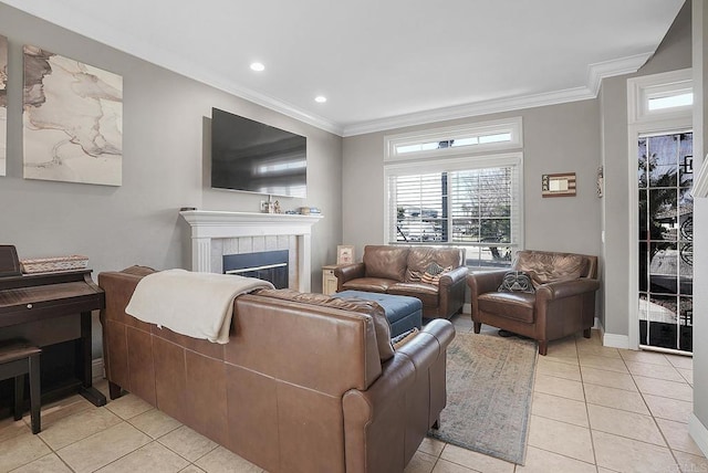 living room with light tile patterned floors, ornamental molding, recessed lighting, and a tile fireplace