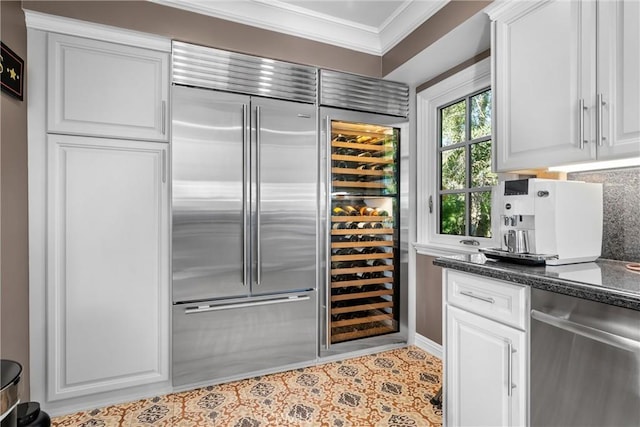 interior space with decorative backsplash, ornamental molding, and white cabinetry