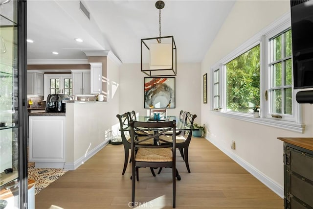 dining space featuring baseboards, visible vents, light wood finished floors, recessed lighting, and ornamental molding