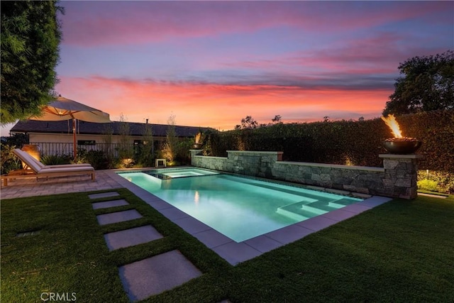 pool at dusk with a patio, a yard, a fenced in pool, and an in ground hot tub