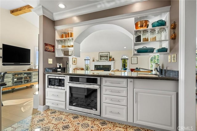 kitchen featuring open shelves, a sink, dark countertops, white cabinetry, and stainless steel appliances