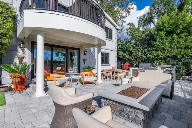 view of patio with an outdoor living space with a fire pit, a balcony, area for grilling, and fence