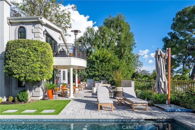 outdoor pool with fence and a patio area