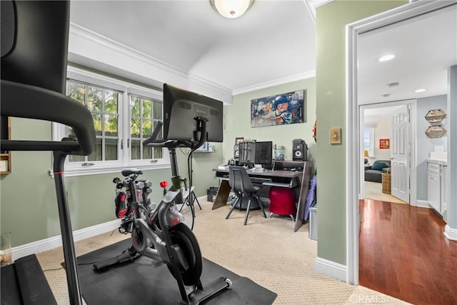 exercise room featuring baseboards, carpet floors, and ornamental molding