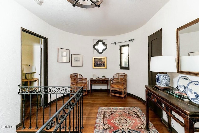 hallway with an upstairs landing, dark wood-type flooring, and baseboards