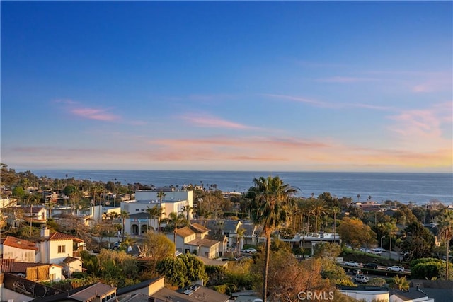 aerial view at dusk featuring a water view