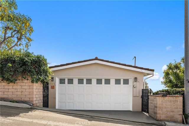 garage featuring fence and driveway