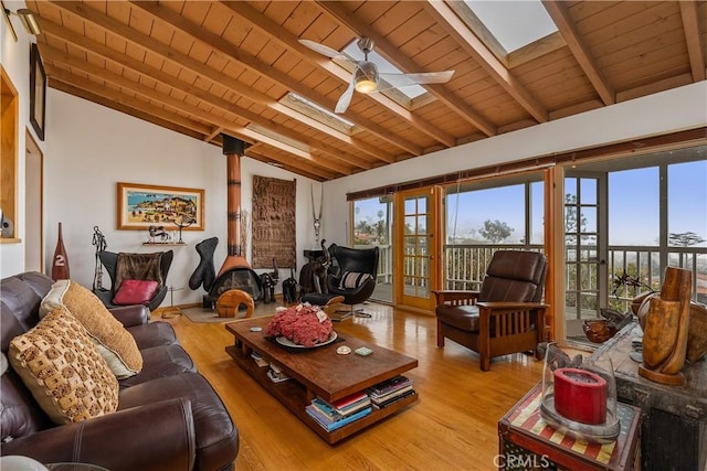 living room featuring ceiling fan, lofted ceiling with skylight, wood ceiling, french doors, and wood finished floors