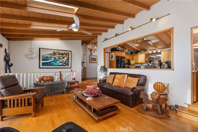 living room featuring lofted ceiling with skylight, a notable chandelier, wooden ceiling, and wood finished floors