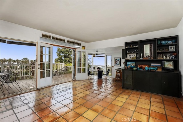 interior space with light tile patterned floors, french doors, plenty of natural light, and ceiling fan