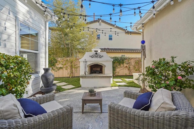 view of patio / terrace featuring an outdoor fireplace and fence