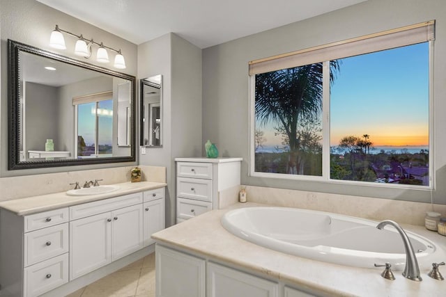 bathroom with tile patterned flooring, vanity, and a garden tub