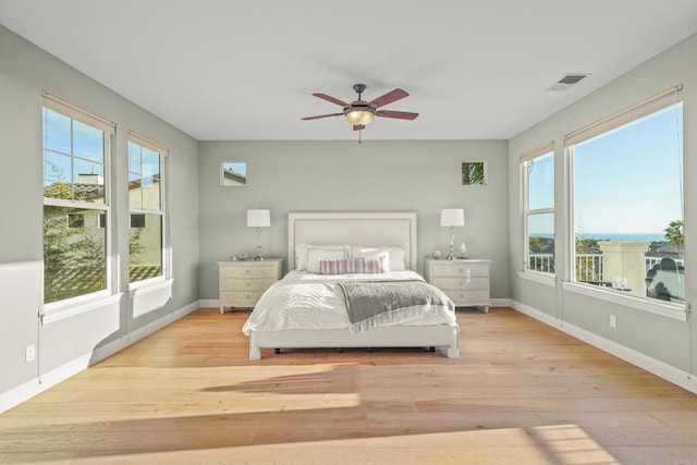 bedroom featuring visible vents, multiple windows, and wood finished floors